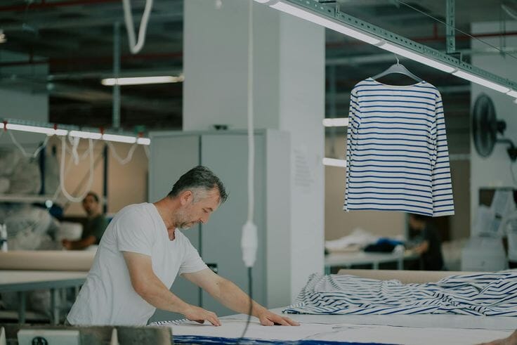 Cutter laying out striped jersey on the cutting table