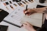 Designer sketching technical flats in a notebook