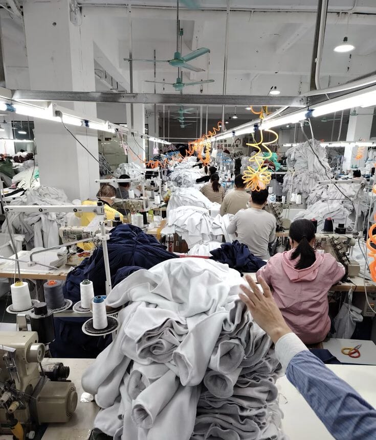 Operator handling finished pieces on a sewing line