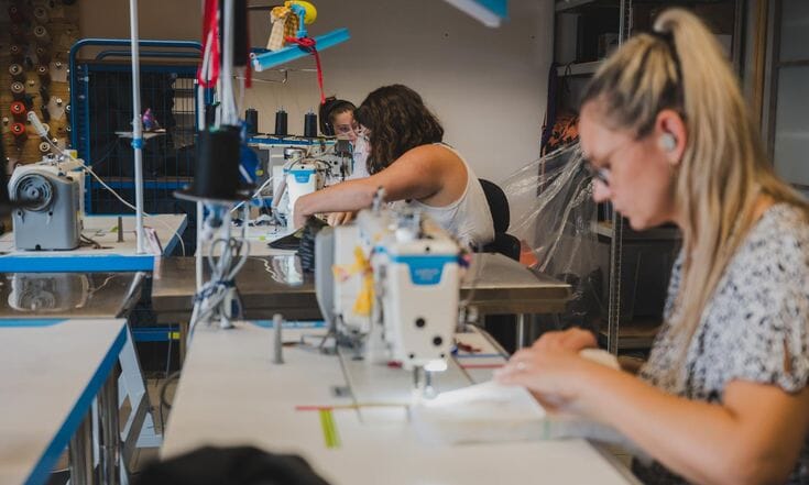 Operator sewing at a flatbed machine
