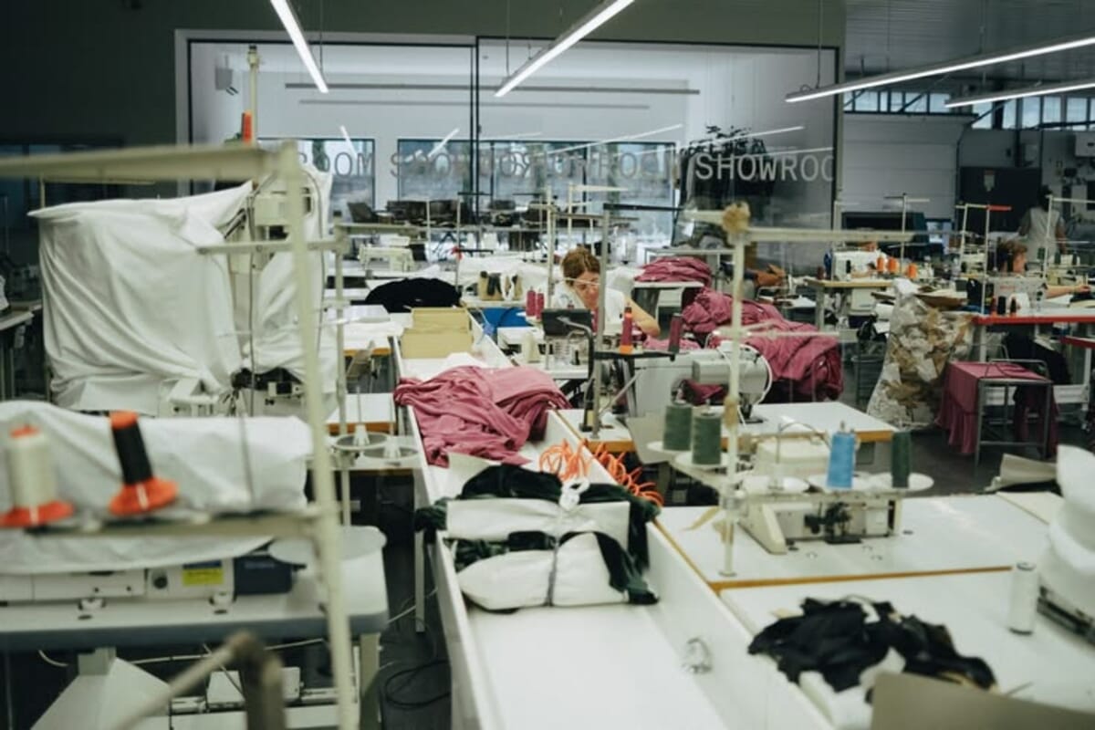 Hangers with garments in a fashion design factory, representing a capsule collection in preparation.