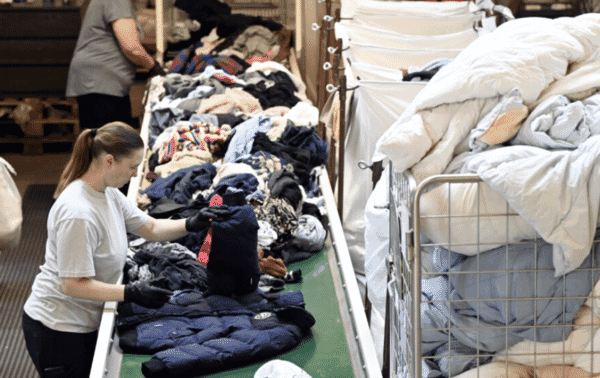 Worker sorting finished garments on a table
