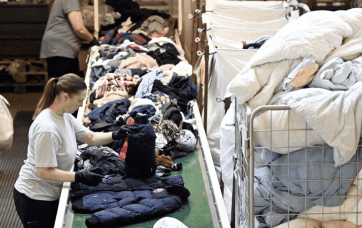 Worker sorting finished garments on a table