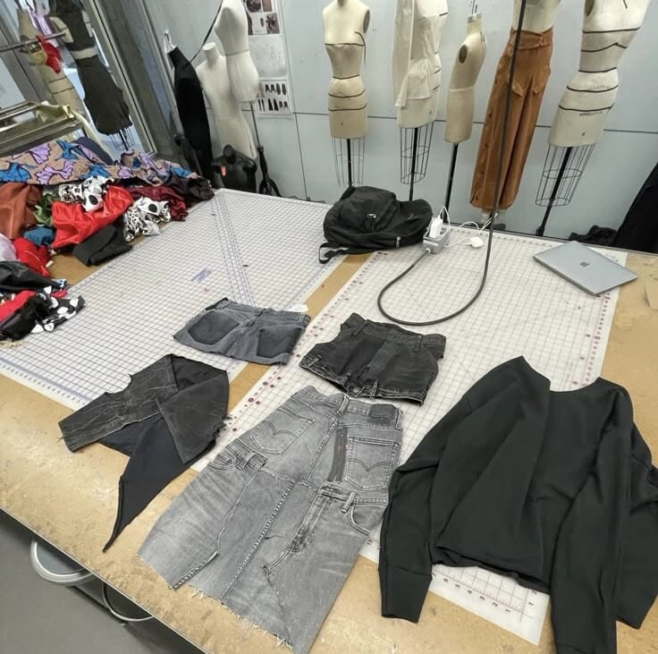 Interior of a Portuguese textile factory with organised fabric rolls next to industrial sewing machines on a clean production floor.