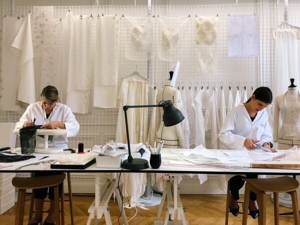 Sample makers fitting toiles on dress forms