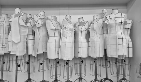 Row of dress forms with fitting lines