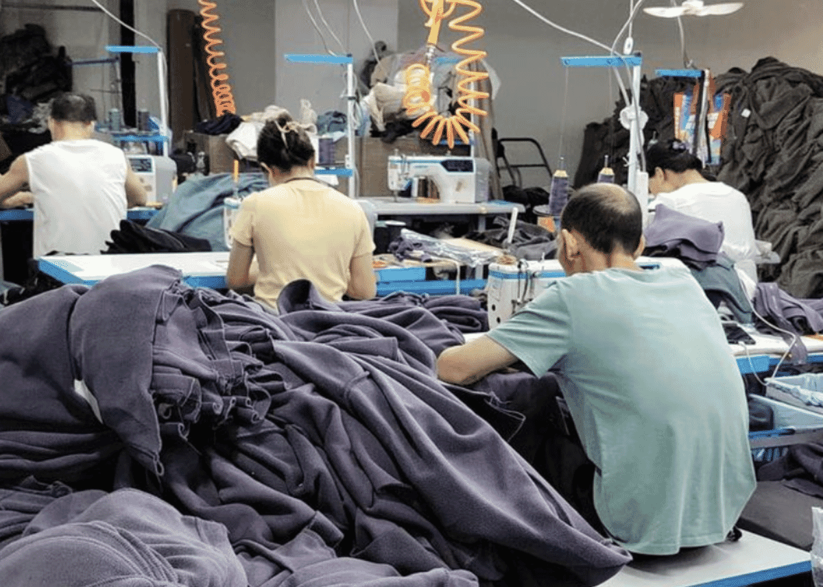 Garment worker operating machinery on a t-shirt production floor