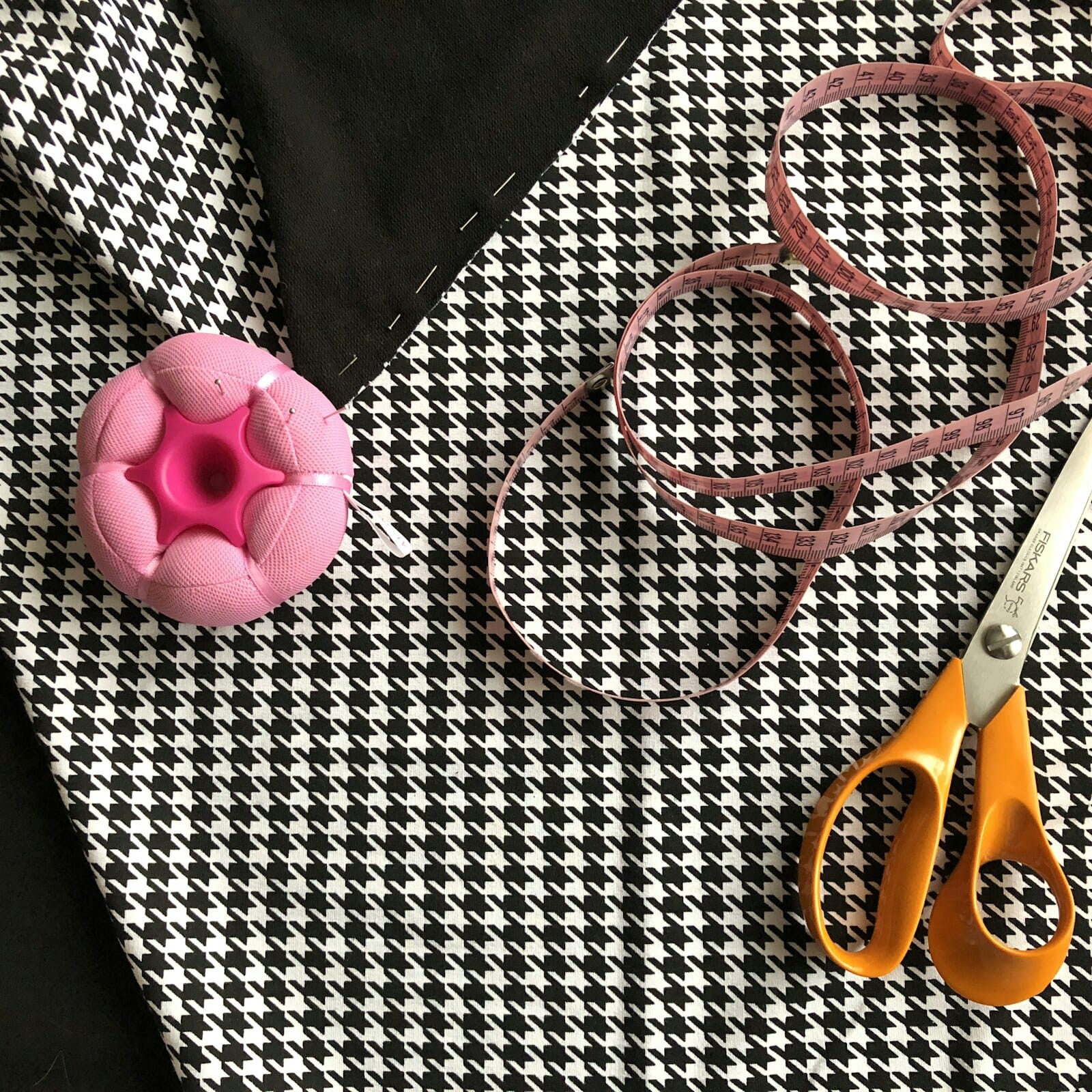 Houndstooth fabric with a tape measure, pincushion and shears