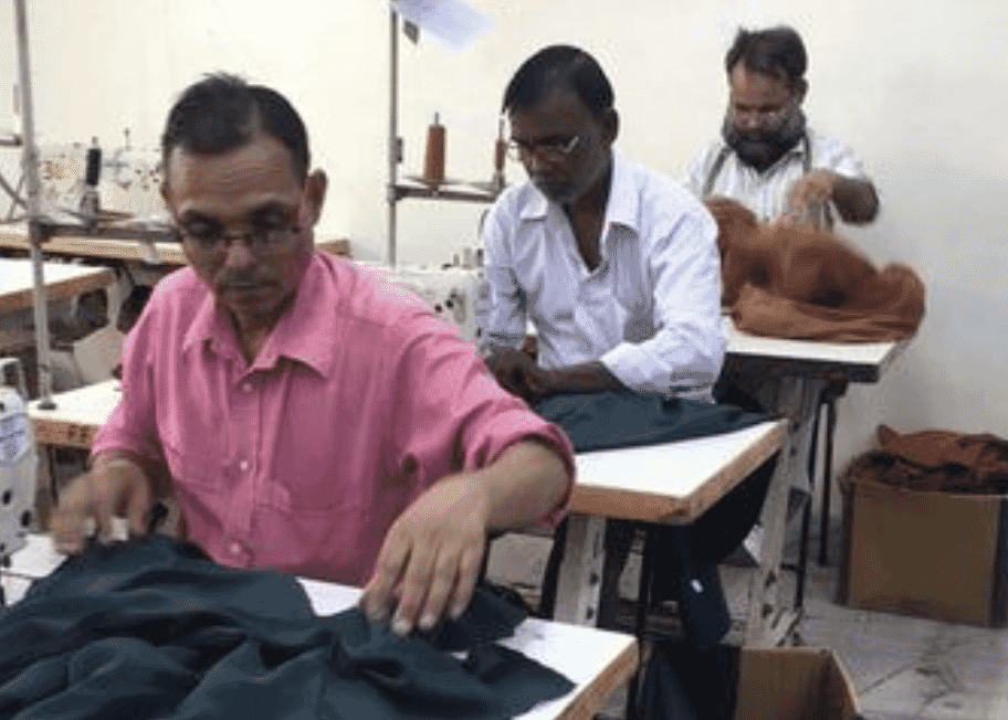 Garment workers sewing and checking cut pieces at their stations