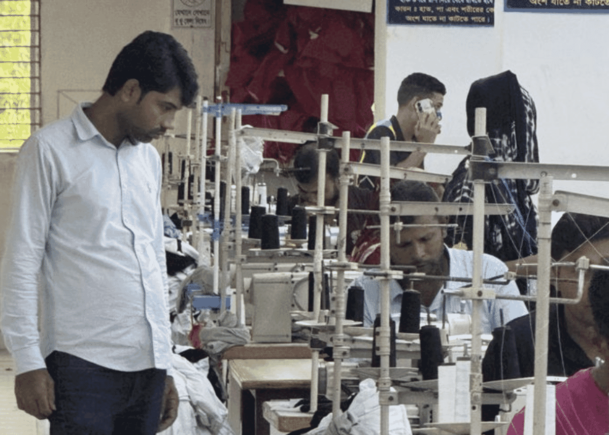 Sewing line with operators and a supervisor on a garment production floor
