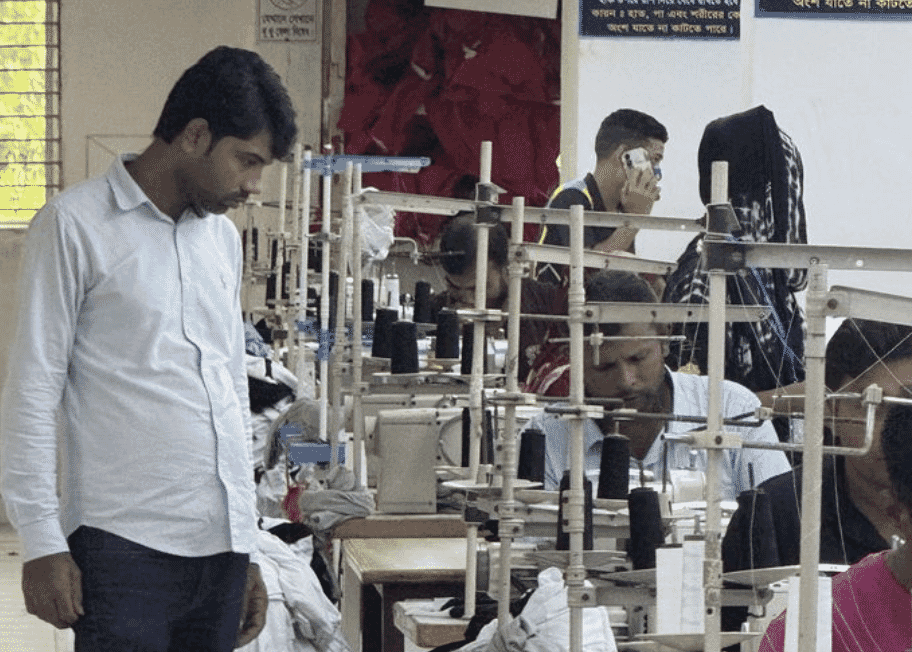 A line supervisor watching sewing operators on a factory floor