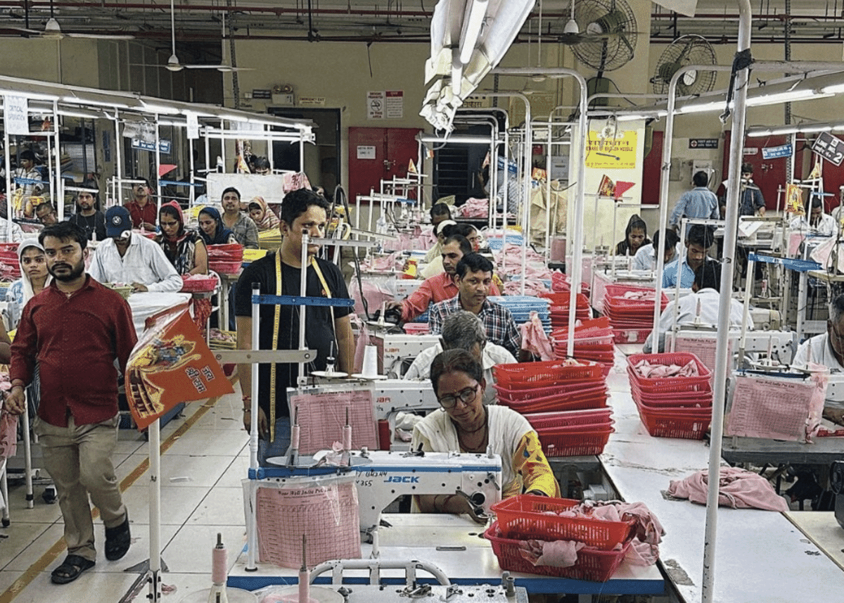 Operators at sewing machines on a large garment factory floor