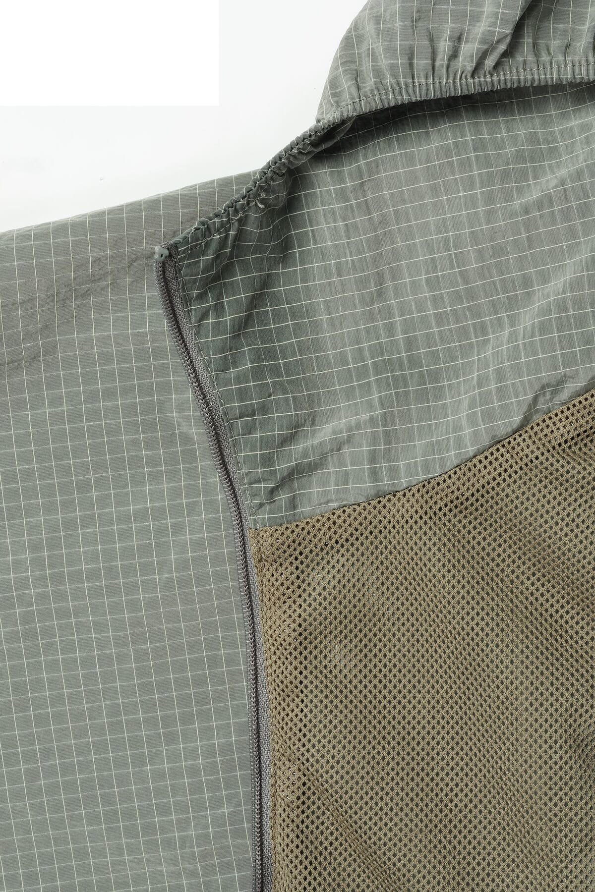 Grey ripstop nylon jacket with a zip opening and an olive mesh lining