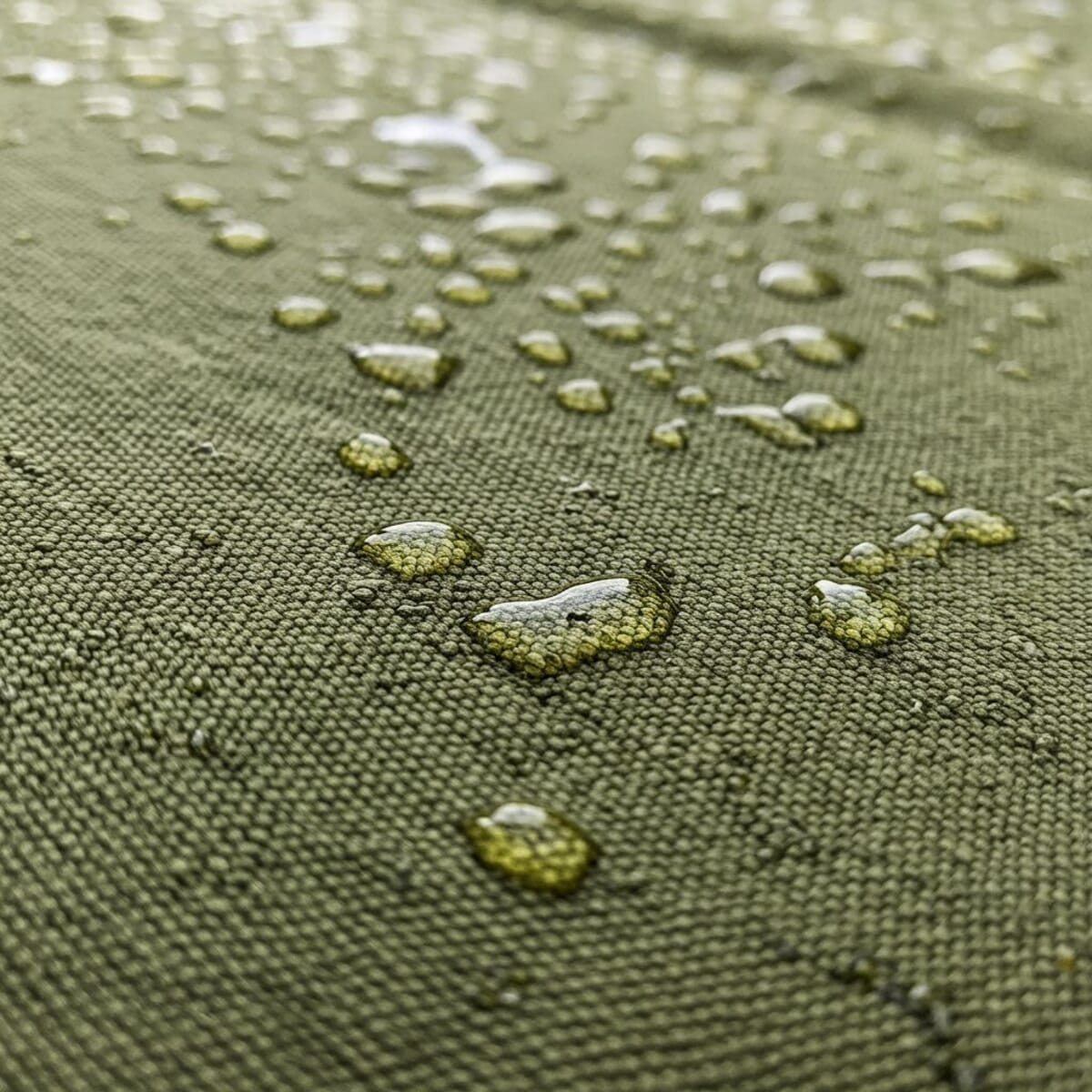 Gotas de água pousadas sobre um tecido verde-oliva de trama fechada