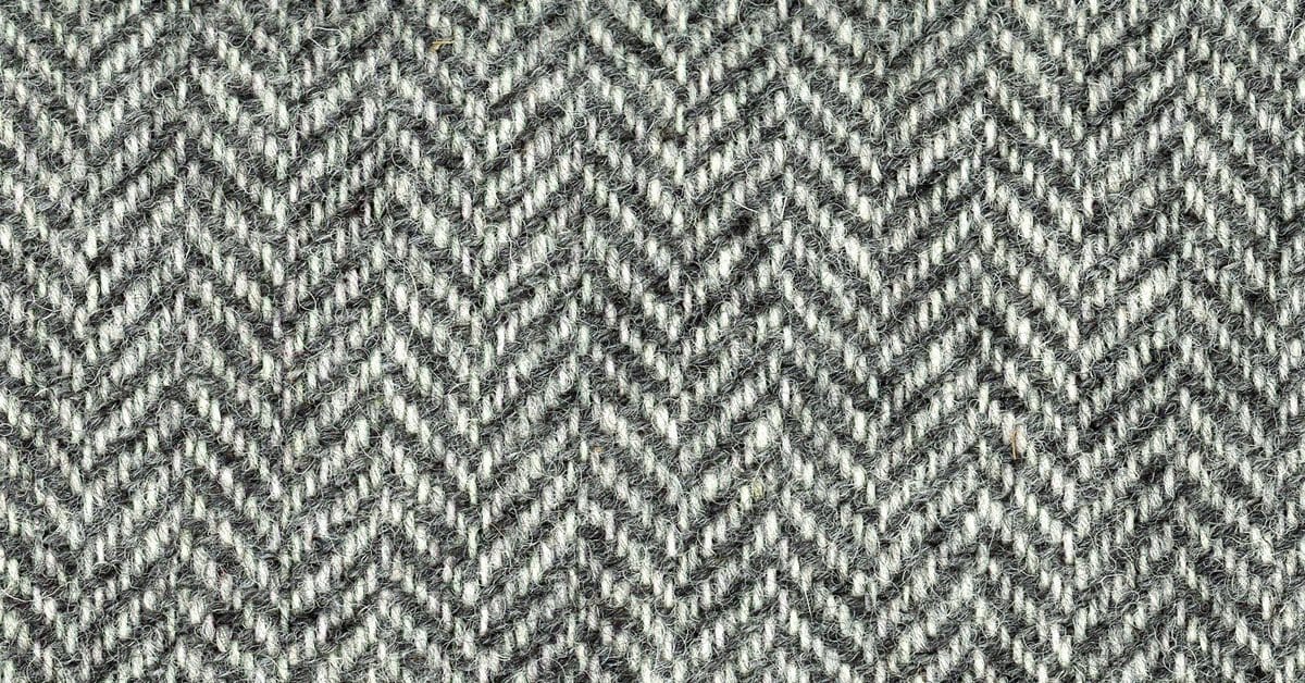 Grey and white herringbone wool tweed in close-up