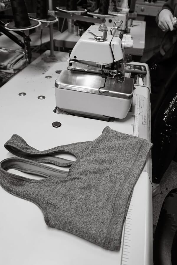 Grey sports bra on the table of a coverstitch machine