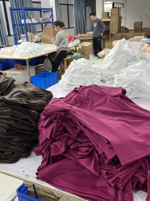 Stacks of folded activewear on finishing tables