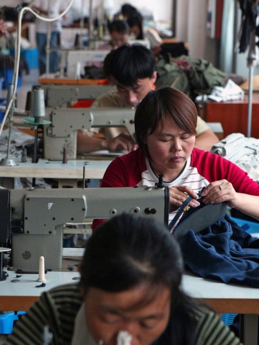 Operators sewing navy garments at lockstitch machines