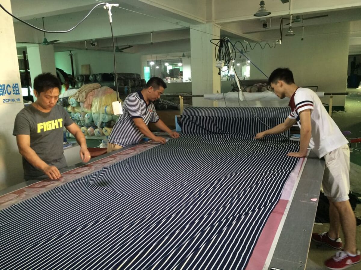 Spreading striped fabric on the cutting table