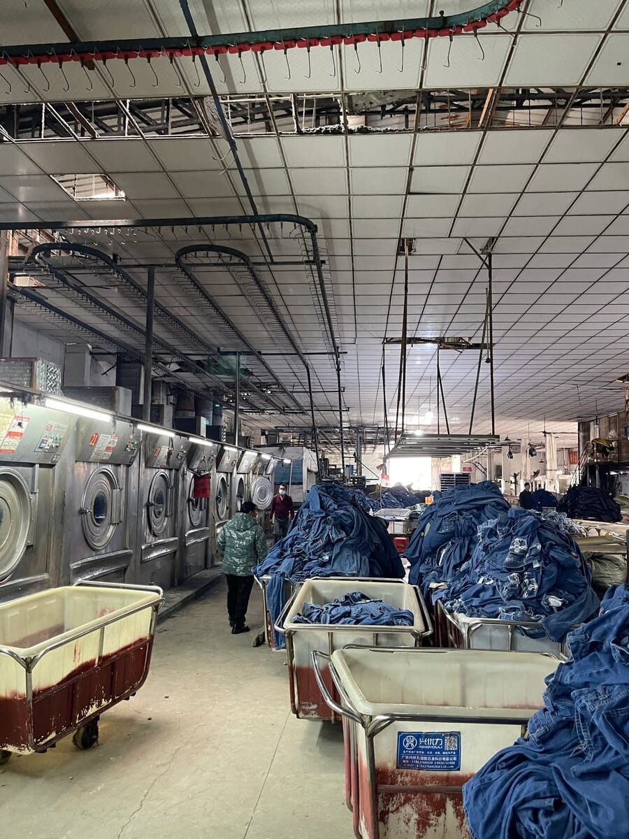 Industrial washers and carts of denim in a wash plant