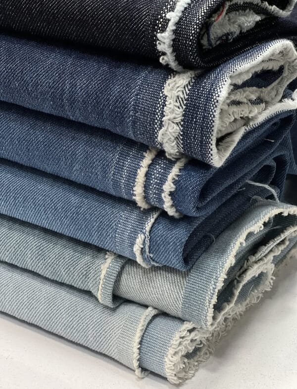 Stacked denim from dark rinse to light wash with frayed edges