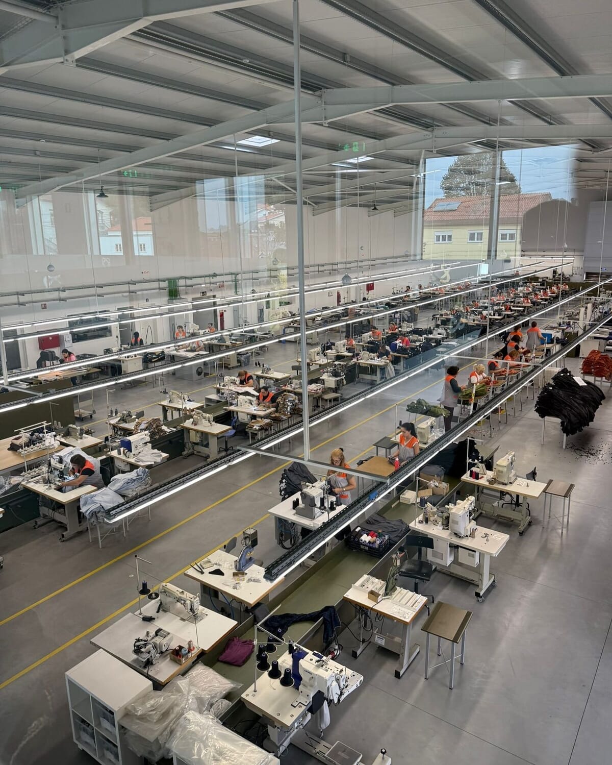 Long garment sewing floor with rows of sewing machines under a high glazed roof