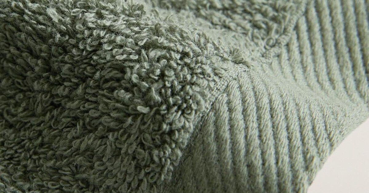 Cotton terry towel close-up showing the loop pile and the flat woven border