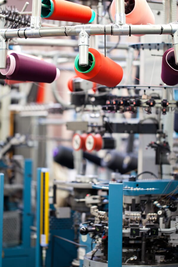Coloured yarn cones feeding a sock knitting machine