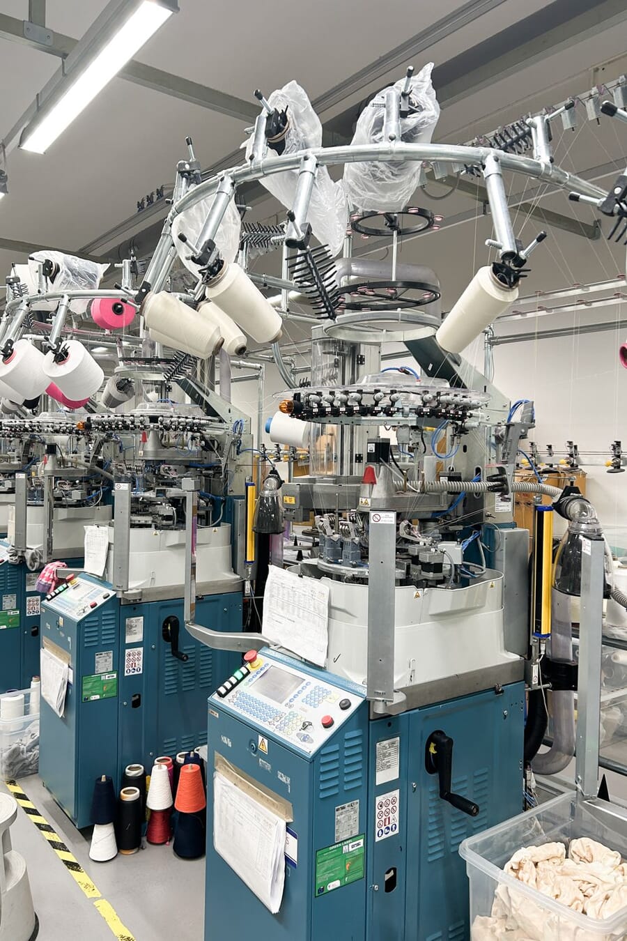 Sock knitting machine with yarn cones feeding from above