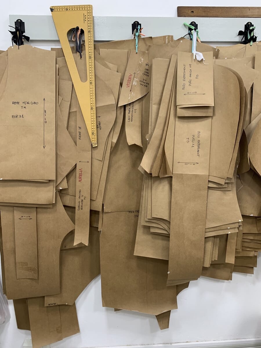 Brown paper patterns hanging on hooks with a pattern ruler