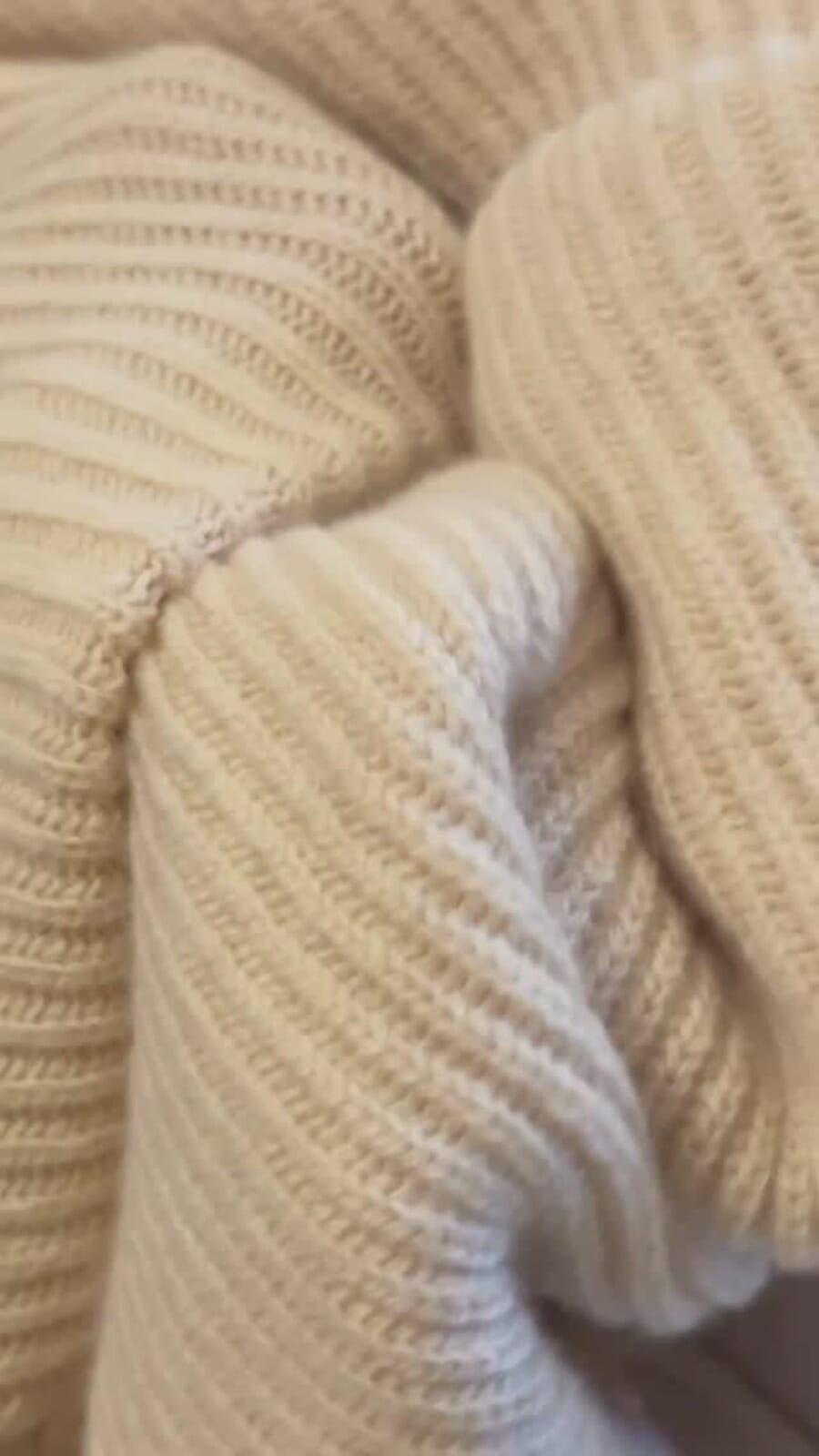 Close-up of a cream rib-knit sweater