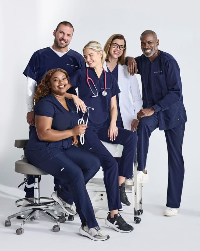 Medical team in matching navy scrubs with names embroidered on the chest