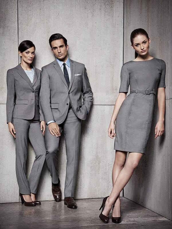 Three office staff in matching grey suits and a grey dress