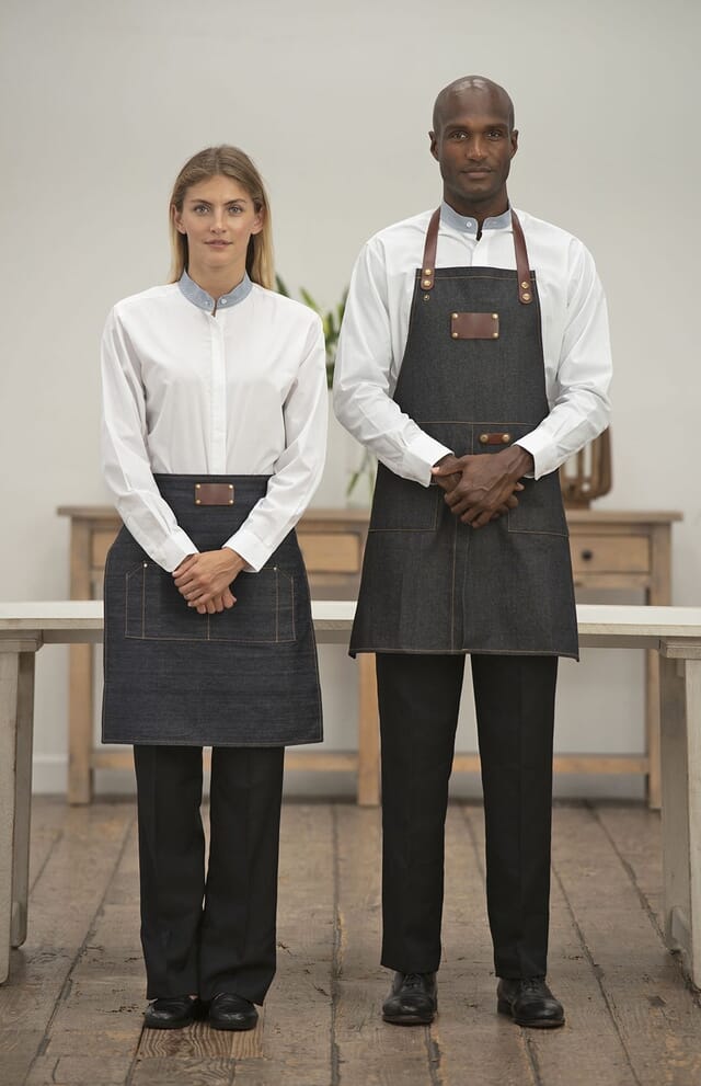 Dois empregados de mesa com aventais de ganga