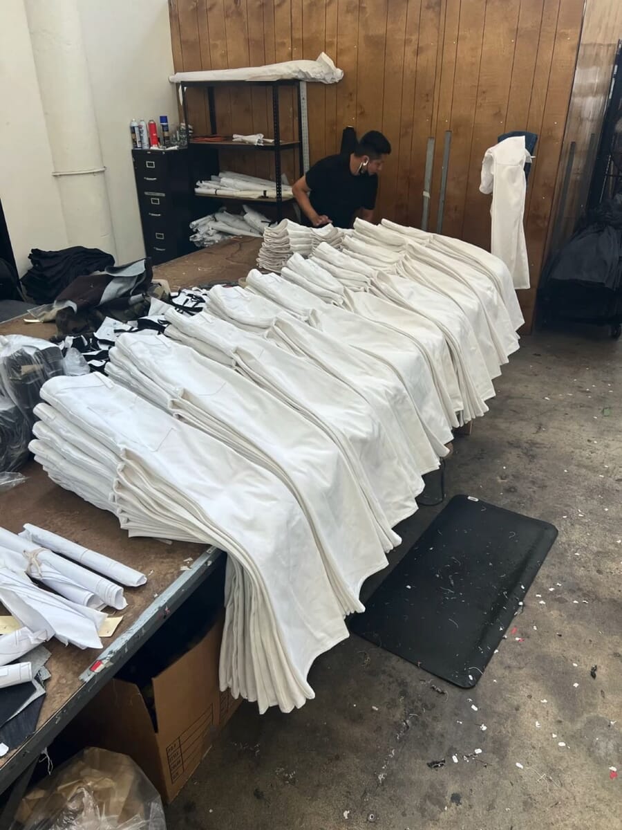 Piles of finished white garments stacked on a work table