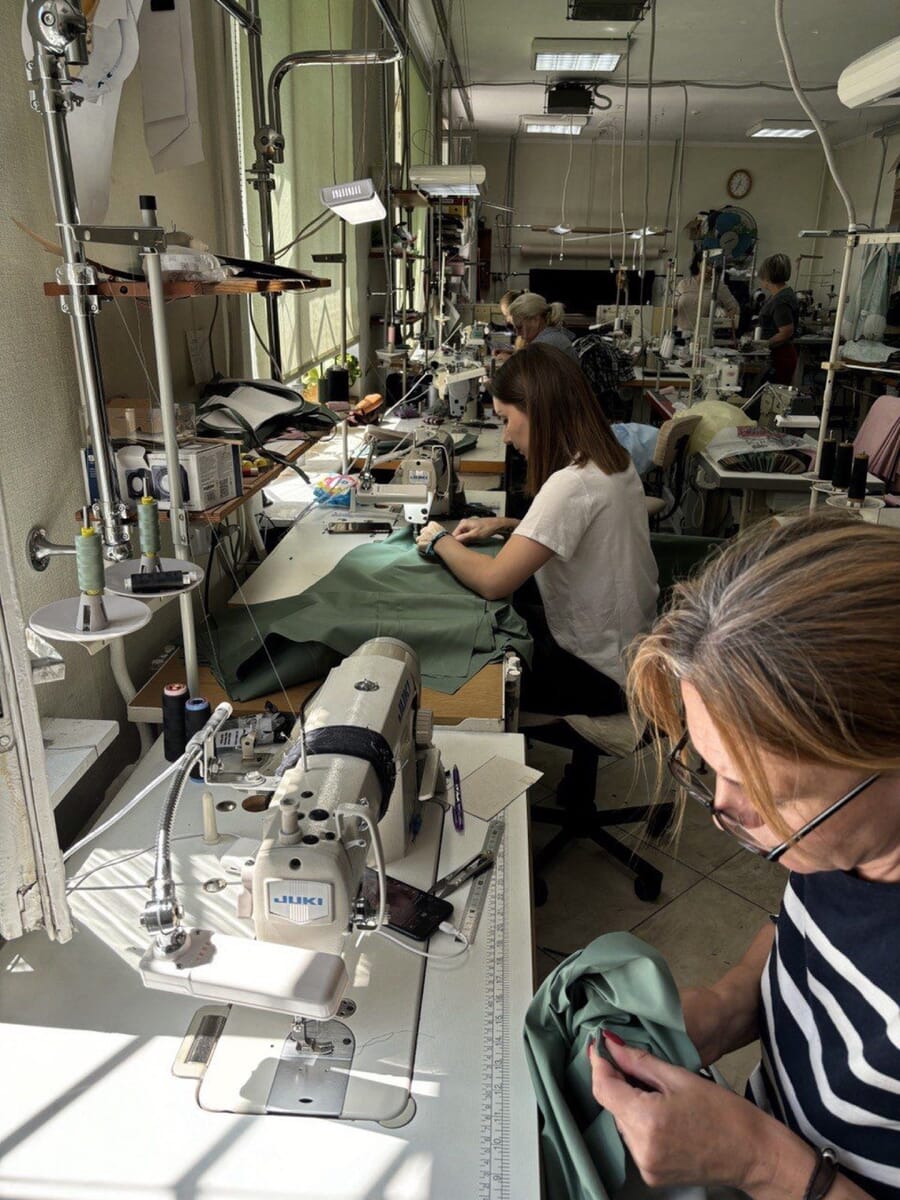 Two operators sewing at single-needle machines in a bright workroom