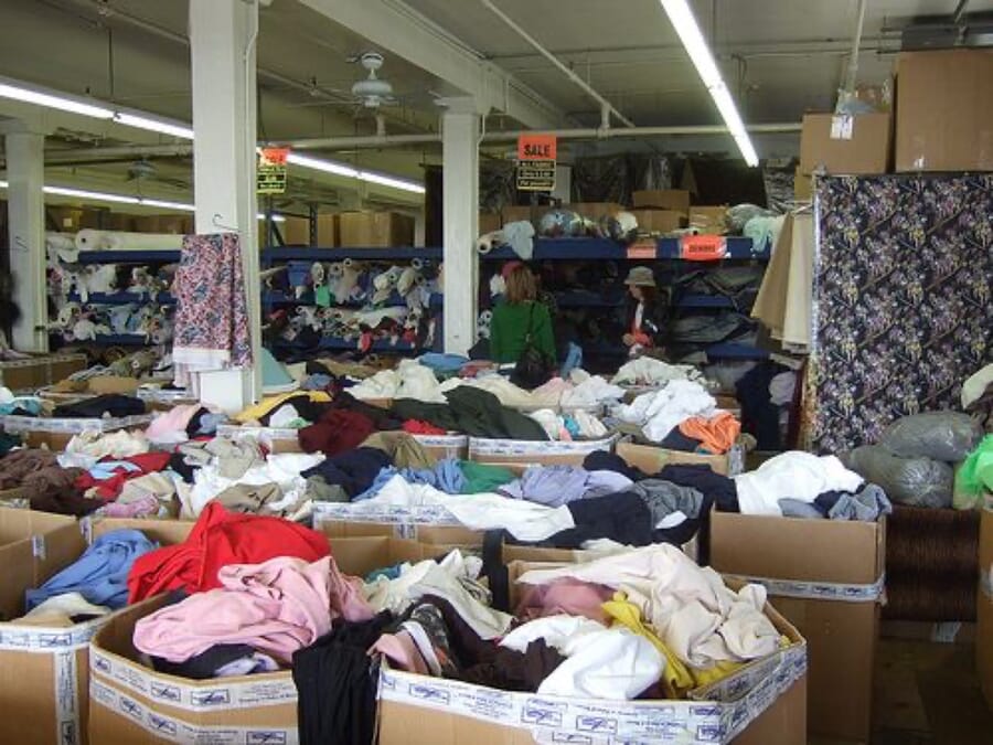 Boxes full of cut fabric pieces sorted on the floor of a garment factory