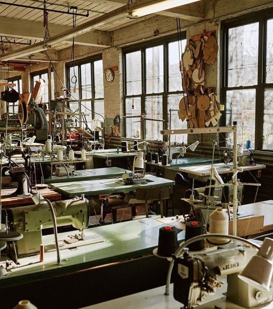 Old garment workroom with sewing machines and racks of patterns under tall windows