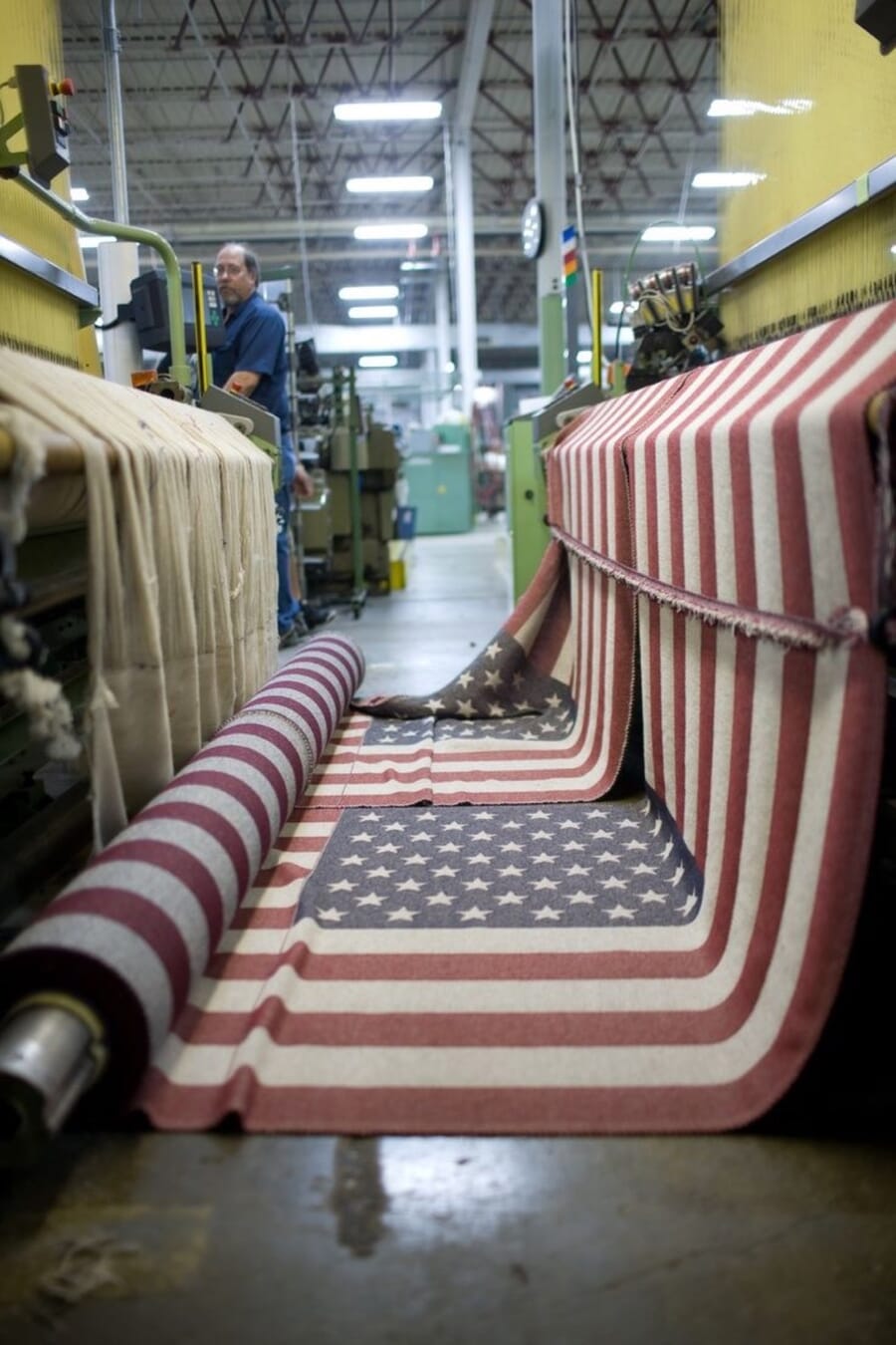 Long run of striped flag fabric coming off a roll in a textile plant