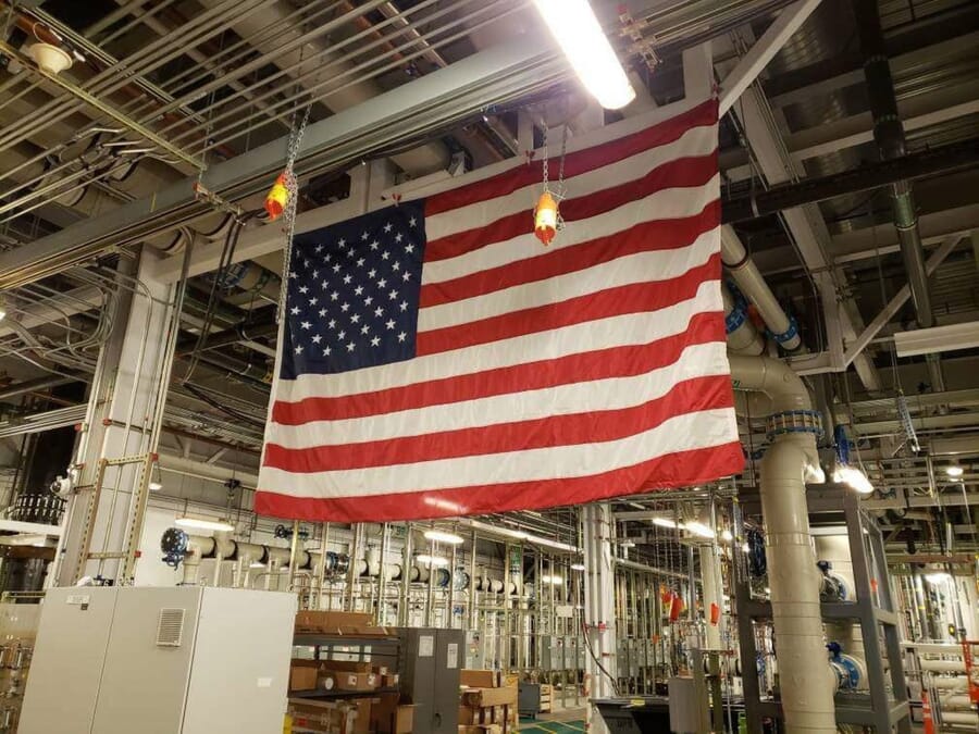 Large US flag hanging from the ceiling of an industrial factory
