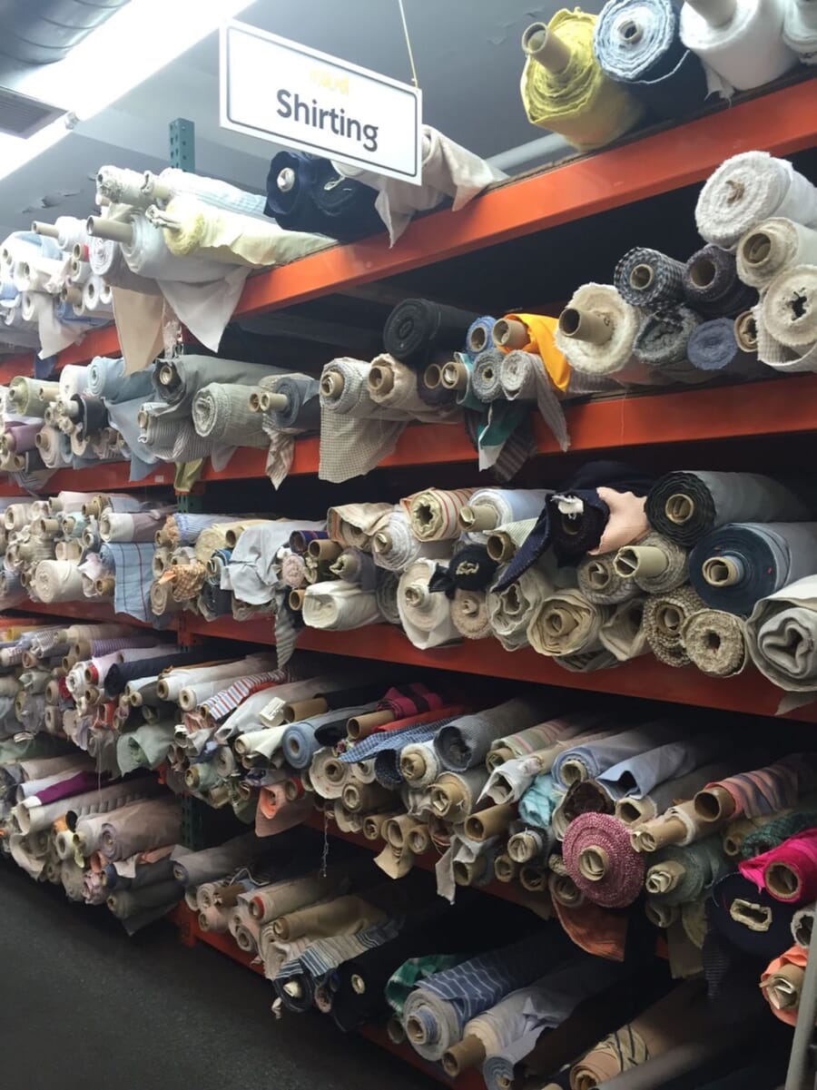 Shelves of rolled shirting fabrics in a fabric store