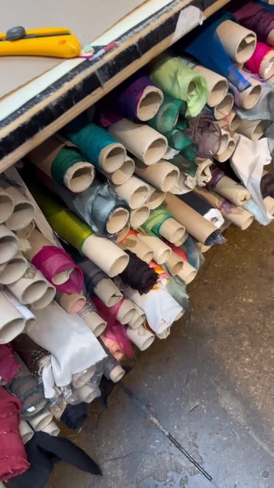 Bin of colourful fabric bolts in a fabric store