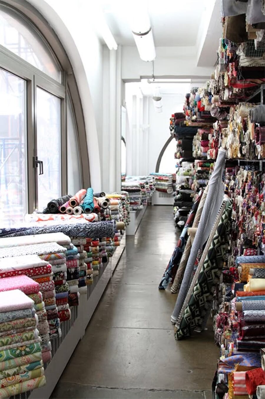 Fabric store with rolls along the walls and tall arched windows