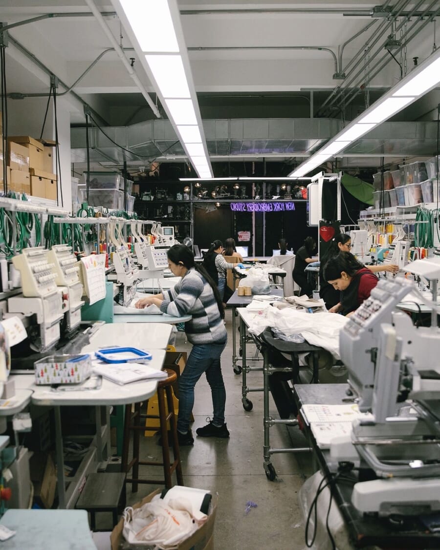 Operators at sewing stations along a busy production line
