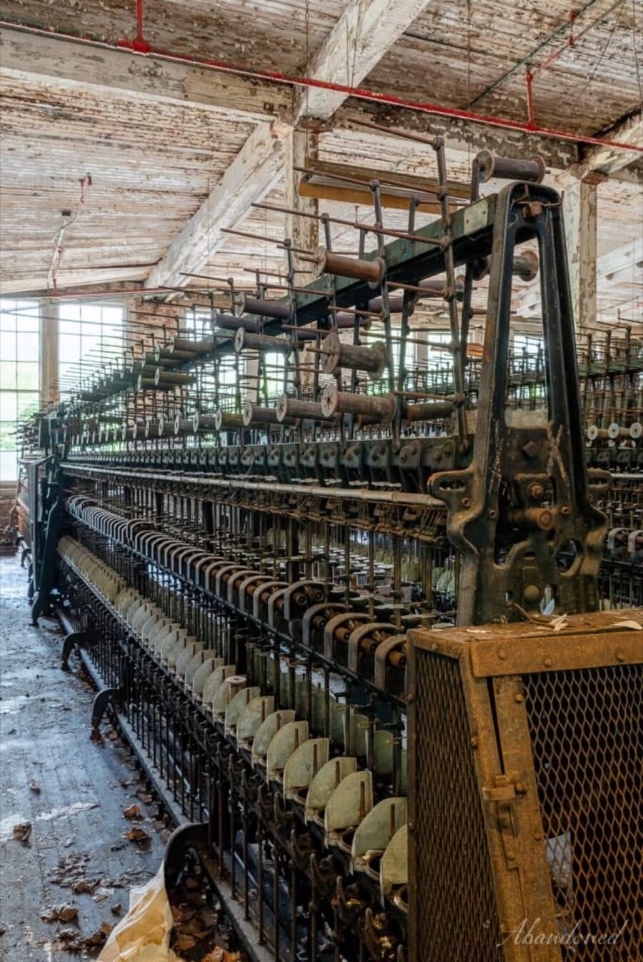 Old textile machine under the skylights of a brick mill