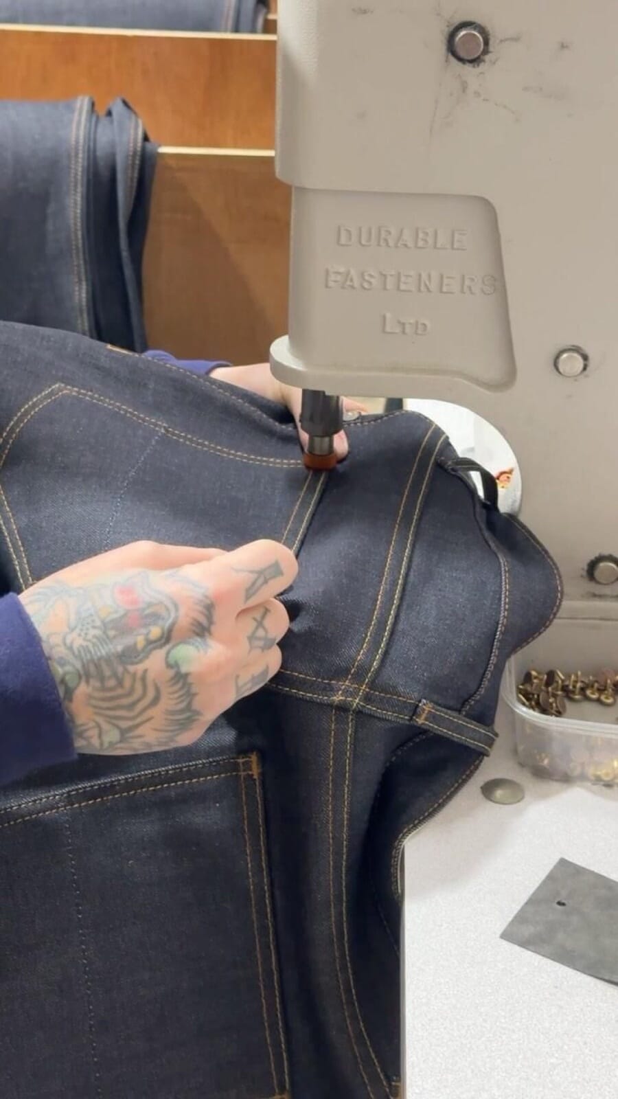 Operator turning a raw denim jean at the sewing machine
