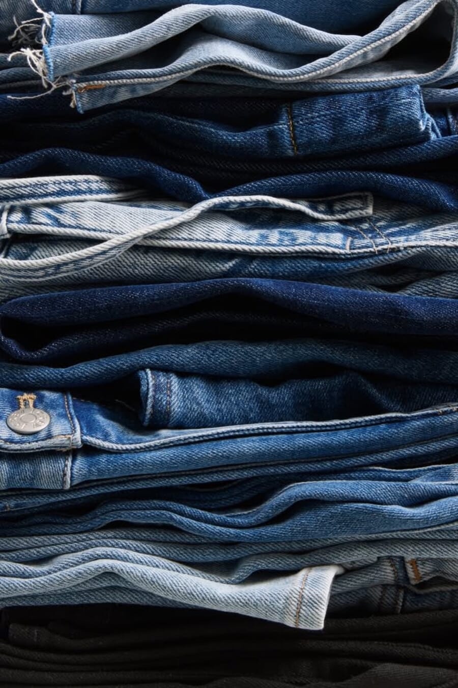 Stack of folded jeans in light, mid and dark washes