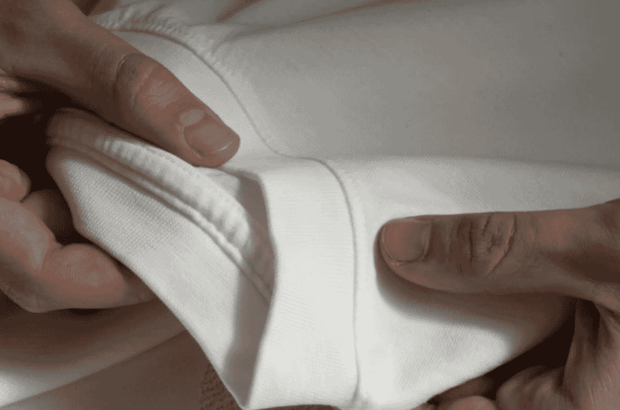 Hands checking the ribbed hem of a sweatshirt