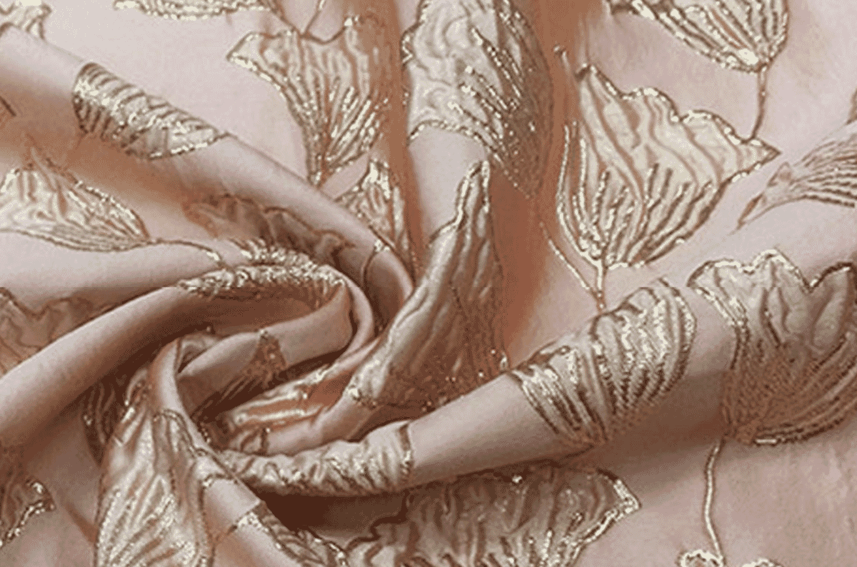 Pink satin jacquard with raised metallic gold floral motifs woven in, the supplementary metallic weft that defines brocade.