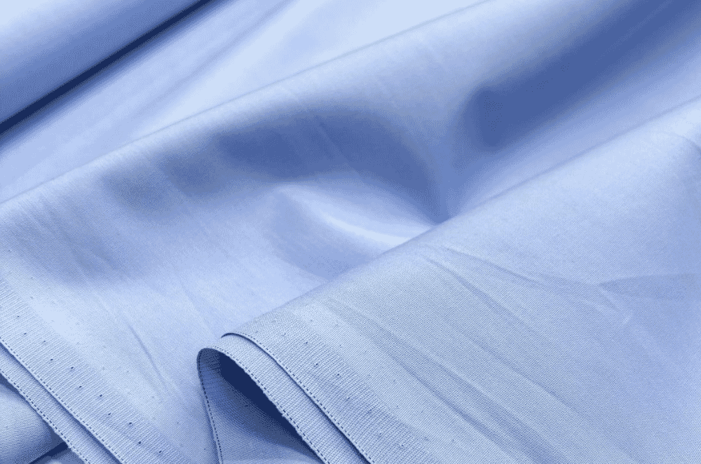Close-up of crisp cotton poplin fabric with a smooth face and subtle horizontal rib, the fine plain-weave construction used for dress shirts and blouses.
